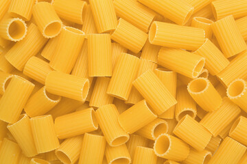 Raw rigatoni pasta as background, top view