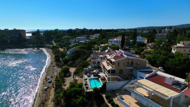 Aerial Shot Of Luxurious Resorts On Cliff By Beach Against Clear Sky, Drone Flying Forward During Sunny Day - Paphos, Cyprus