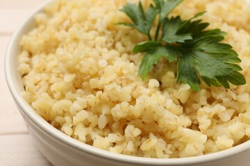 Delicious bulgur with parsley in bowl, closeup
