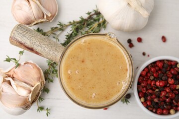 Delicious turkey gravy, garlic, thyme and peppercorns on white table, flat lay