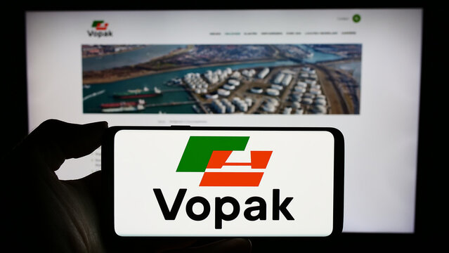 Stuttgart, Germany - 11-23-2023: Person holding cellphone with logo of Dutch storage company Koninklijke Vopak N.V. in front of business webpage. Focus on phone display.