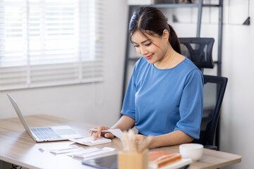 asian woman using calculator and calculate bills in home office. tax form us business income office Financial document. Tax time.Tax concept. - obrazy, fototapety, plakaty