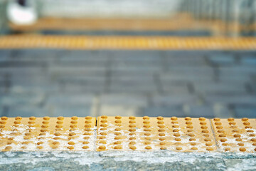 Yellow snowy braille blocks before stairway, yellow bumpy tile on first step of stairs for blind...