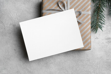 White new year card mockup, blank christmas card with copy space, gift box with fir tree branch