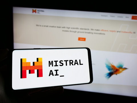 Stuttgart, Germany - 11-27-2023: Person holding cellphone with logo of French artificial intelligence company Mistral AI SAS in front of business webpage. Focus on phone display.