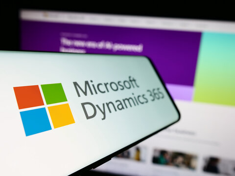 Stuttgart, Germany - 11-27-2023: Cellphone with logo of accounting software product Microsoft Dynamics 365 in front of business website. Focus on left of phone display.