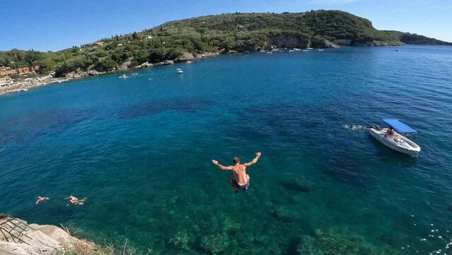 Adventurous young man jumping off a cliff from a bar into the sea in Greece ,adventurous lifestyle