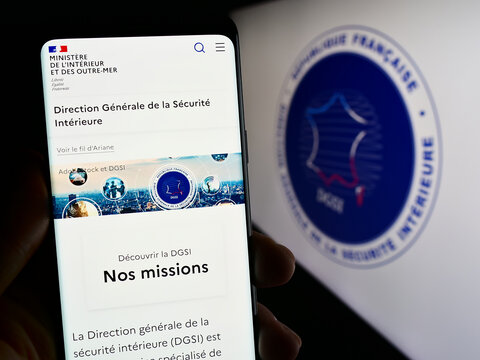 Stuttgart, Germany - 11-27-2023: Person holding cellphone with webpage of Direction G&eacute;n&eacute;rale de la S&eacute;curit&eacute; Int&eacute;rieure (DGSI) in front of logo. Focus on center of phone display.