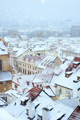 Prague in winter time, view on snowy roofs with historical buildings.