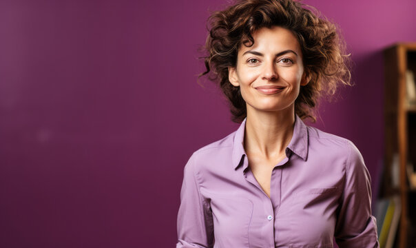 Confident Central European non-binary person in their 40s with curly hair, wearing a lilac shirt, standing against a purple background