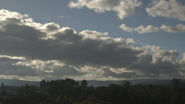 1 minute timelapse of cumulus clouds forming and dispersing over a pine forest in Galicia. Sun setting and dispersing the clouds and then hiding behind new cumulus cloud formations Atmospheric weather