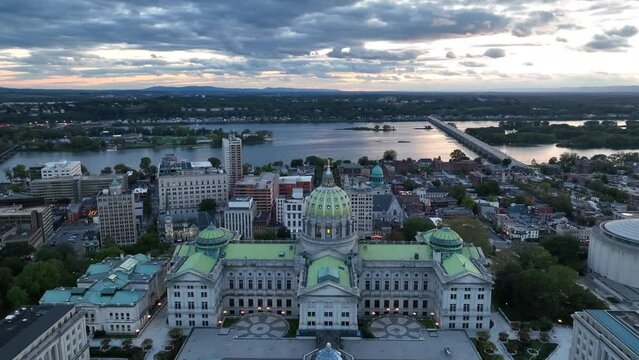 Pennsylvania State Capitol Building with the Susquehanna River in the background in Harrisburg PA at sunset. Aerial orbit.
