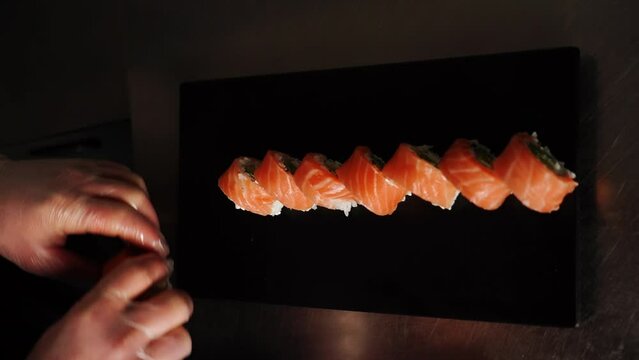 Sushi man prepares sushi. Close up of hands. Concept of preparing sushi and rolls. Vertical video