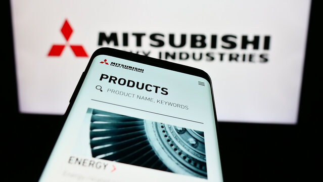 Stuttgart, Germany - 11-28-2023: Mobile phone with website of Japanese company Mitsubishi Heavy Industries Ltd. (MHI) in front of logo. Focus on top-left of phone display.
