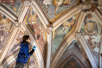 Female Expertise Restorer Retouching Antique Gothic Fresco Under Church Ceiling - Parish Church,...