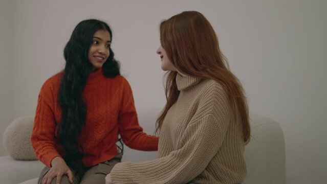 Best friends hug. Ladies emotion, youthful and happiness of women. Two pretty smiling girls sitting together and hugging at home. Females embracing and excited. Woman friendship.