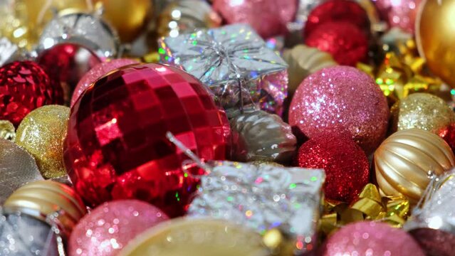 Christmas Ornaments Background Rotation, Spinning. Close up a Glitter Christmas Tree Decoration Items is Turning. Backdrop of New Year Ornate. Many Shiny Xmas Bauble, Balls and Bulbs. Top View, Frame