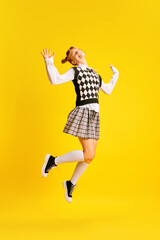Happy smiling girl, student highly jumping dressed retro fashion outfit because winter holidays...