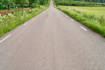 Close-up view of grey asphalt road with road markings