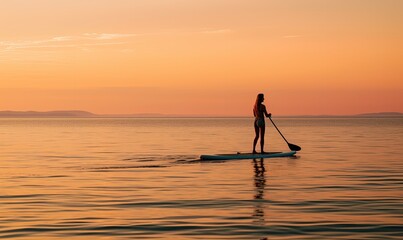 Photo of a Serene Paddle Boarder Gliding Across the Glistening Waters