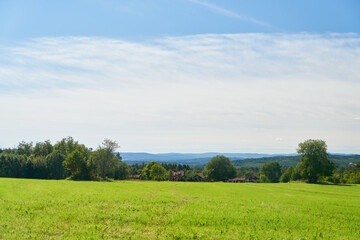 Fototapeta premium Green field on farmland with cloudy sky in Sweden in summer