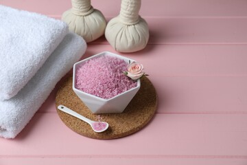 Composition with sea salt and herbal bags on pink wooden table. Space for text