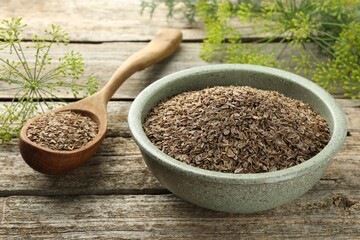 Dry seeds and fresh dill on wooden table