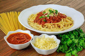 Spaghetti bolognese pasta with chili sauce paste and coriander served in dish isolated on table side view of arabic food
