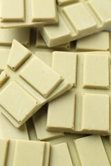 Pieces of tasty matcha chocolate bars as background, above view