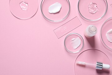 Bottle of cosmetic serum and petri dishes with samples on pink background, flat lay. Space for text