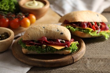 Delicious sandwiches with bresaola, lettuce and cheese on wooden table