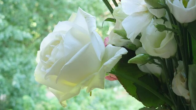 White rose and eustoma flowers in bouquet on blurred background