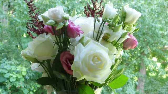 Bouquet of roses and eustoma in vase on blurred background