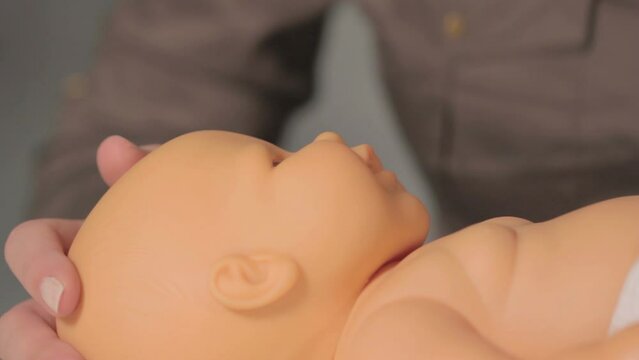Woman performing CPR on baby training doll 