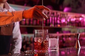 Bartender making fresh alcoholic cocktail at counter in bar, closeup - obrazy, fototapety, plakaty