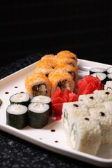 Set of delicious sushi rolls on dark table, closeup