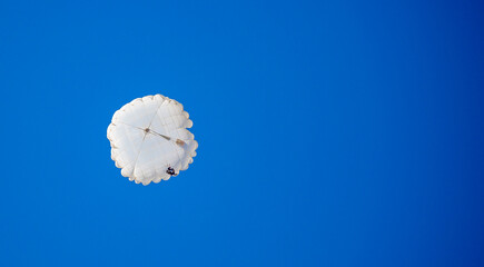 Skydiving. Flying parachutists against the background of the blue sky and mountains. Extreme sport...