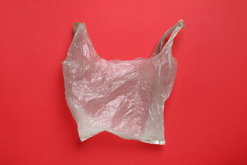 One plastic bag on red background, top view