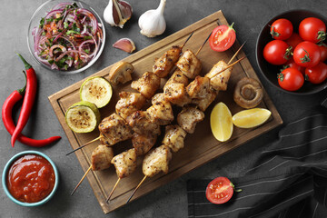 Delicious fresh shish kebabs with sauce served on grey table, flat lay