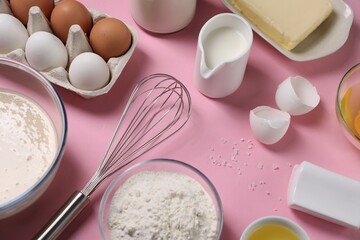 Composition with whisk and dough in bowl on pink background, above view