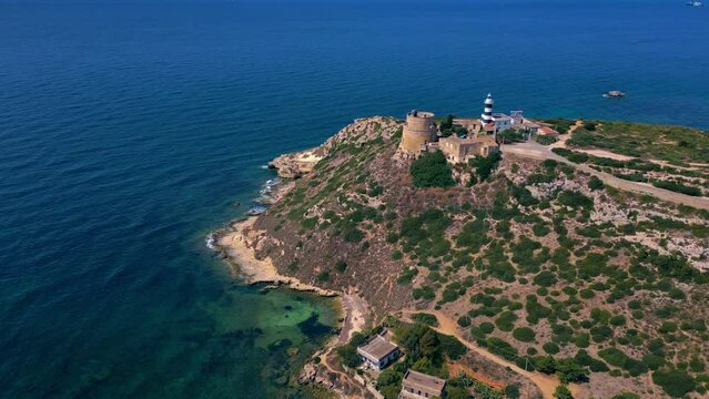 Standing proud on rock and vegetation covered coastline, Calamosca Tower