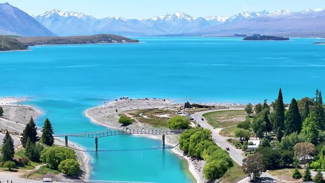 Breathtaking beauty of nature. Lake Tekapo in New Zealand surrounded by mountains, bridge and church.