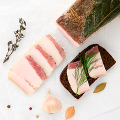 Salted lard bacon pork meat bay leaf, fresh thyme  with black bread sandwich decorated with sprig...