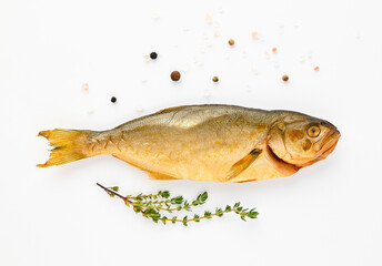 Cold smoked sea fish carcass close up isolated on a white background decorated with a fresh sprig of thyme, crystals of coarse pink salt, and black peppercorns. Salty snacks. Omega3