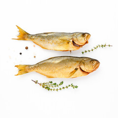 Cold smoked two sea fish carcass close up isolated on white background decorated with fresh sprig of thyme, crystals of coarse pink salt, black peppercorns. Salty snacks. Omega3