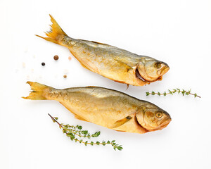 Cold smoked two sea fish carcass close up isolated on white background decorated with fresh sprig of thyme, crystals of coarse pink salt, black peppercorns. Salty snacks. Omega3