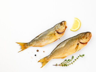 Cold smoked sea fish carcass close up isolated on white background decorated with fresh sprig of thyme, lemon, crystals of coarse pink salt, black peppercorns. Salty snacks. Omega3