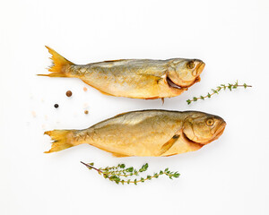 Cold smoked two sea fish carcass close up isolated on white background decorated with fresh sprig of thyme, crystals of coarse pink salt, black peppercorns. Salty snacks. Omega3