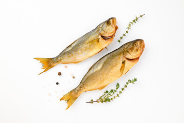Cold smoked two sea fish carcass close up isolated on white background decorated with fresh sprig...