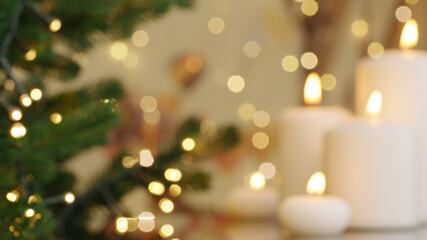 Blurred burning candles close-up Christmas tree decorated on background. Evergreen tree bokeh...